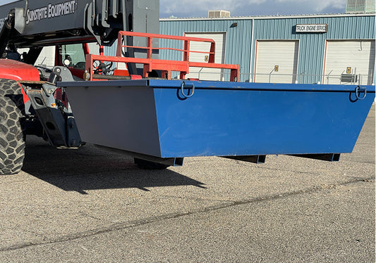 Blue steel washout pan attached to a vehicle on an asphalt surface with a building in the background.
